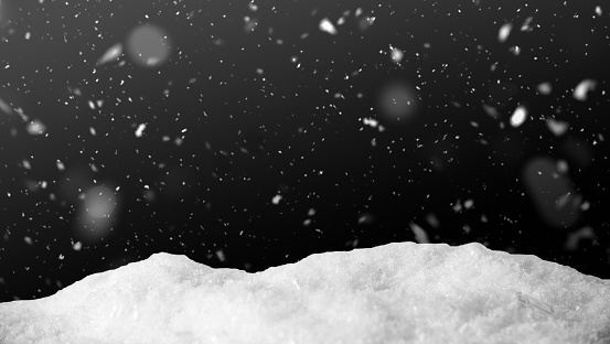 Snow on black background with snowfall. Snowdrift backdrop in the winter night.