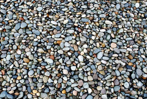 Shiny wet little stones on Pacific ocean shore.