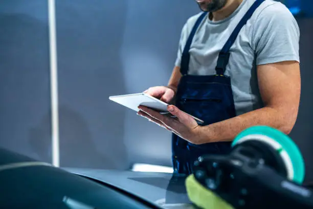 Close up of a male mechanic using a tablet.