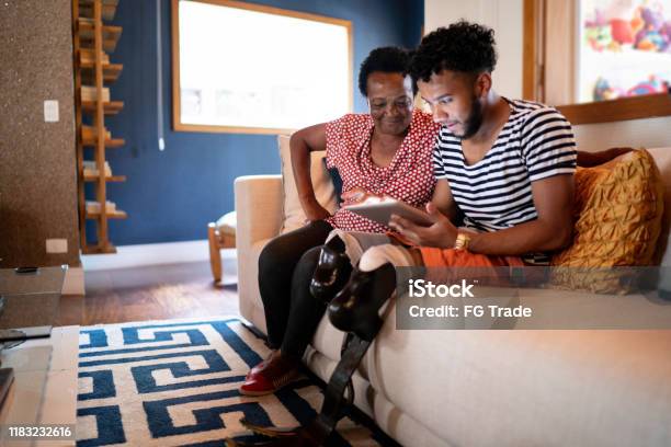Son/Grandson using digital tablet with his mother/grandmother