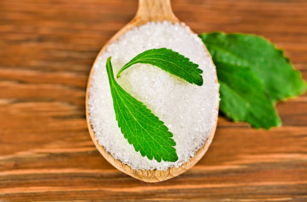 foglie di stevia con zucchero in un cucchiaio di legno - sweetleaf foto e immagini stock