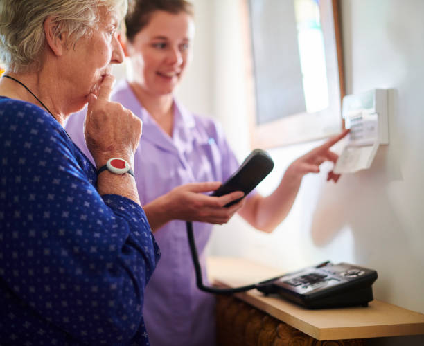 istock home carer showing senior woman her intercom 1183237268