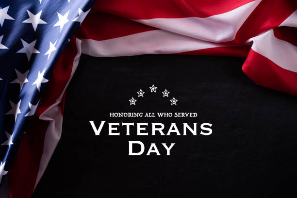 istock Happy Veterans Day. American flags veterans against a blackboard background. 1183246199
