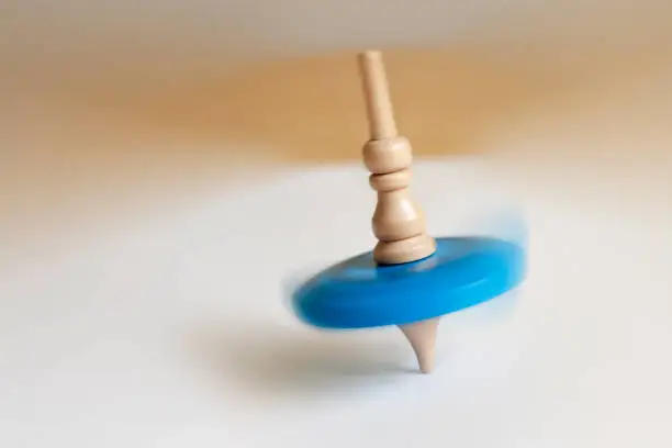 Photo of wooden top toy spinning on a table