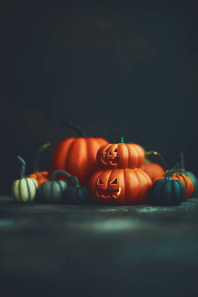 istock Dark Halloween background with Jack O'Lantern and pumpkins 1183246326
