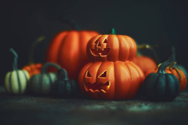 istock Dark Halloween background with Jack O'Lantern and pumpkins 1183246346