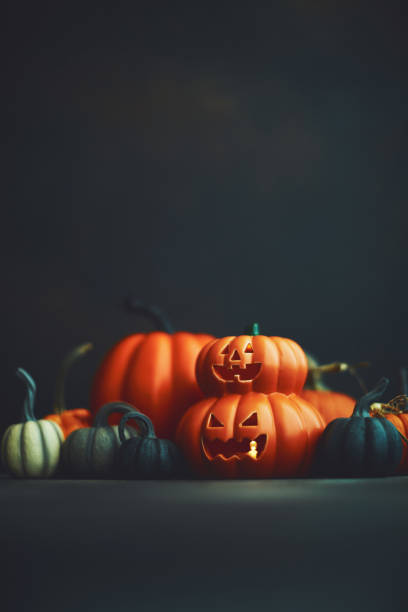 istock Dark Halloween background with Jack O'Lantern and pumpkins 1183246347
