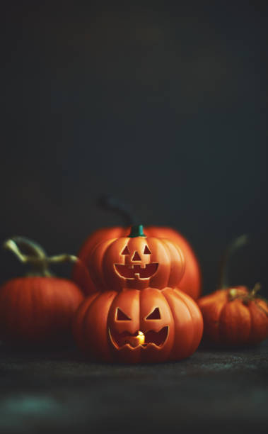 istock Dark Halloween background with Jack O'Lantern and pumpkins 1183246374