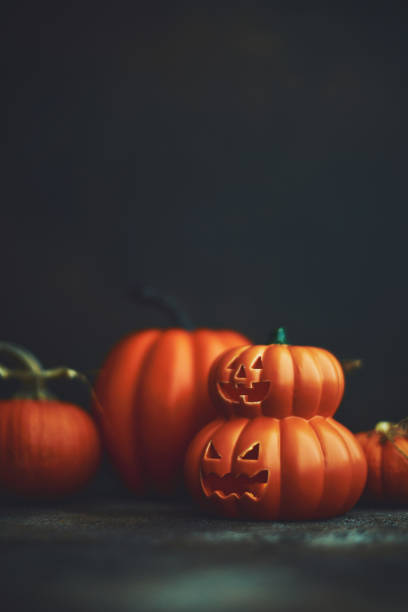 istock Dark Halloween background with Jack O'Lantern and pumpkins 1183246375