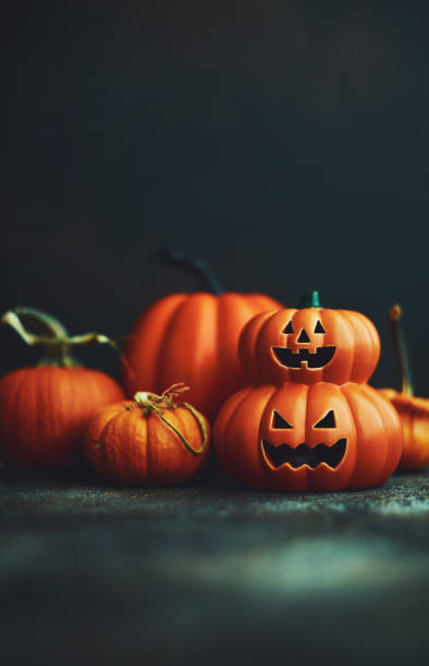 istock Dark Halloween background with Jack O'Lantern and pumpkins 1183246381