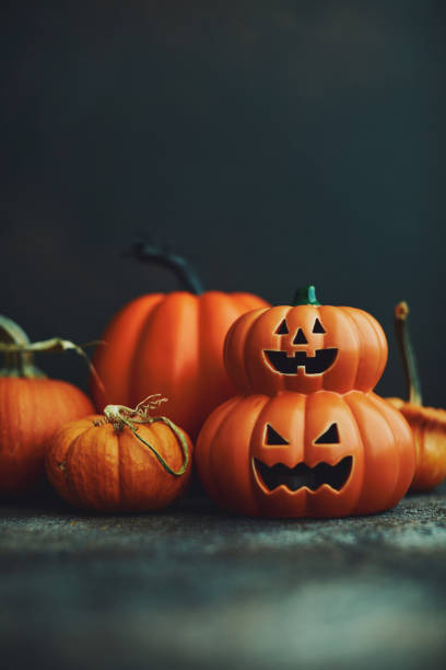 istock Dark Halloween background with Jack O'Lantern and pumpkins 1183246382