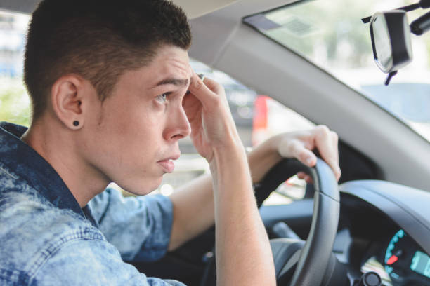 istock Young man checking her face details on a car rear view mirror 1183248939