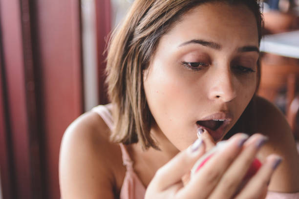 istock Young woman checking her face details on a make-up portable mirror 1183249466