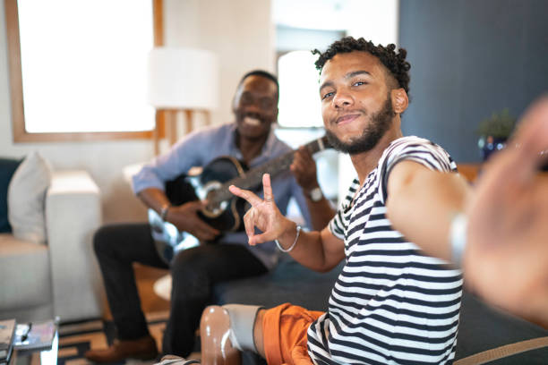 selfie de père et de fils jouant la musique dans la salle de séjour - oncle photos et images de collection