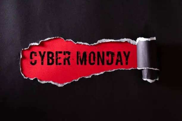 Photo of Top view of Black torn paper and the text Cyber Monday on a red background. Cyber Monday composition.