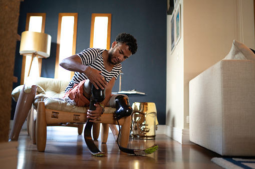 Joven poniendo pierna protésica en casa photo