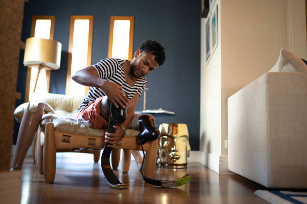 Young man putting prosthetic leg at home