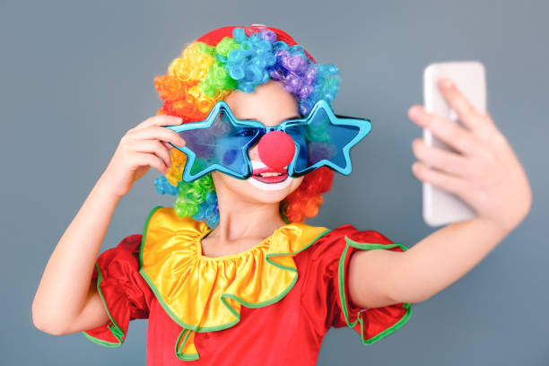 comic girl in a clown suit and stupid eyeglasses doing selfie - clown circus telephone humor imagens e fotografias de stock