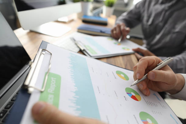 istock Two businessman hold in arms financial papers 1183253634