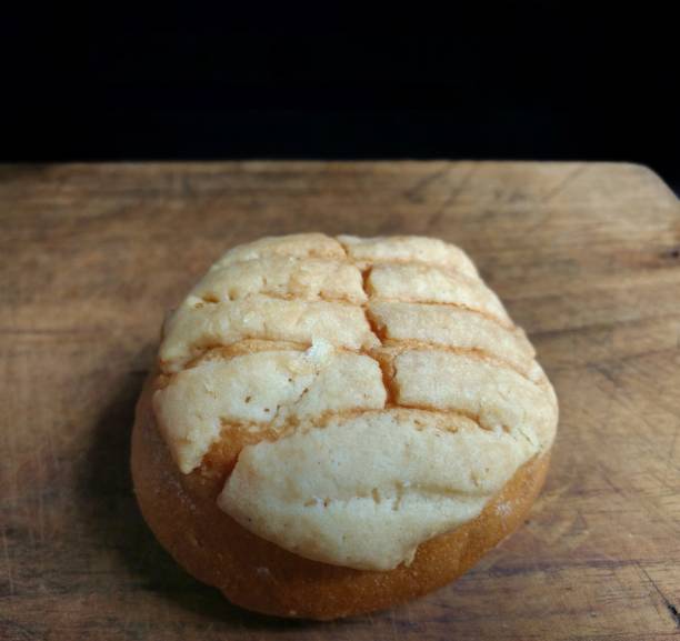 istock Close-up of handmade shell bread on wooden board with black background. typical mexican bread 1183254417