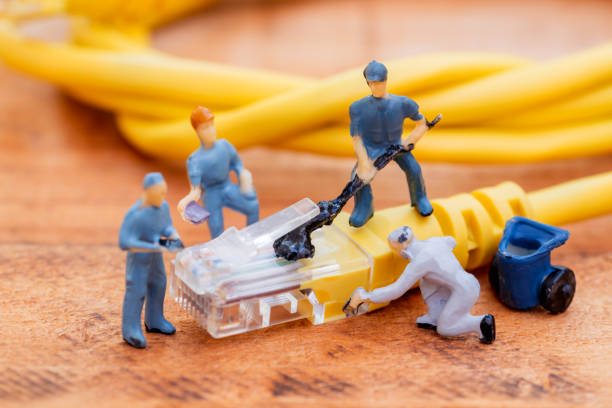 Close up miniature technician teamwork maintenance rj45 with network cable. telecommunication concept.
