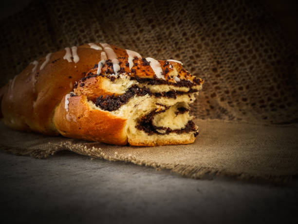 istock Fresh poppy seed roll on natural linen napkin on rustic wooden background 1183257332