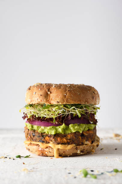 Healthy veggie burger Healthy veggie burger with vegan pattie, guacamole, onion and sprout veggie burger photos stock pictures, royalty-free photos & images