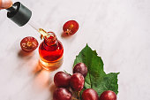 Grape seed oil. Pipette with oil, serum and a bottle close-up. Selective focus