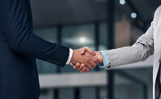 Cropped shot of two businessmen shaking hands in a modern office