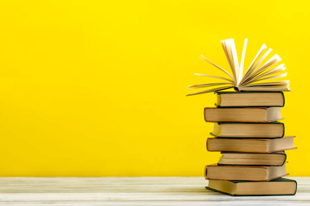 istock Open book, hardback books on wooden table. Back to school. Copy space 1183288620