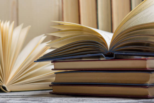 istock Open book, hardback books on wooden table. Back to school. Copy space 1183288674