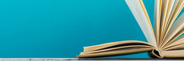 istock Open book, hardback books on wooden table. Back to school. Copy space 1183289789