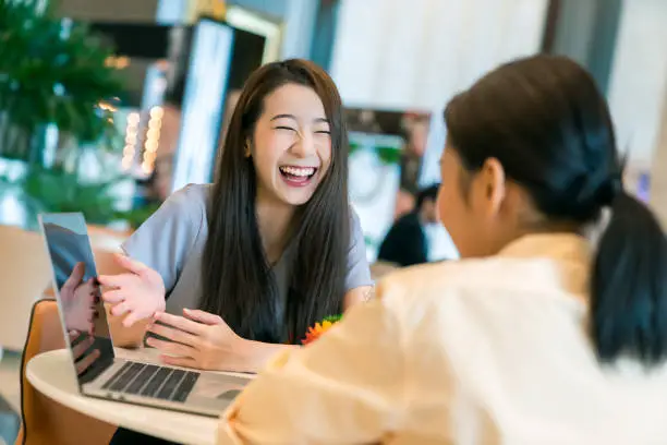 Photo of beautiful attractive business female present new project with smile and joyful to client with laptop and modern office background