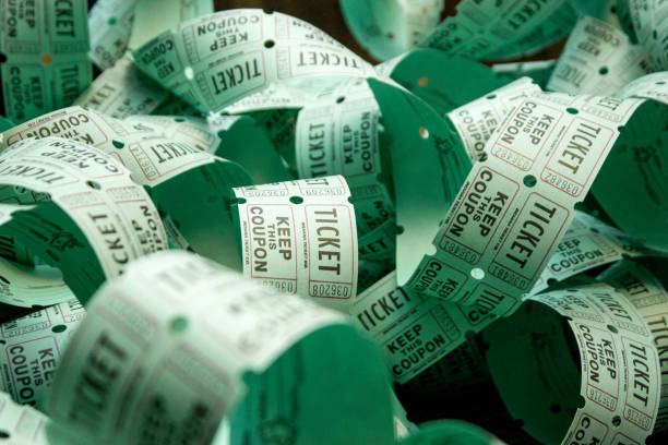 Unrolled roll of green admit one raffle tickets An unrolled and unravelled roll of green admit one coupon raffle tickets for lottery or raffles of charity or entertainment prizes. One side is the winning ticket in a drawing. jackpot photos stock pictures, royalty-free photos & images