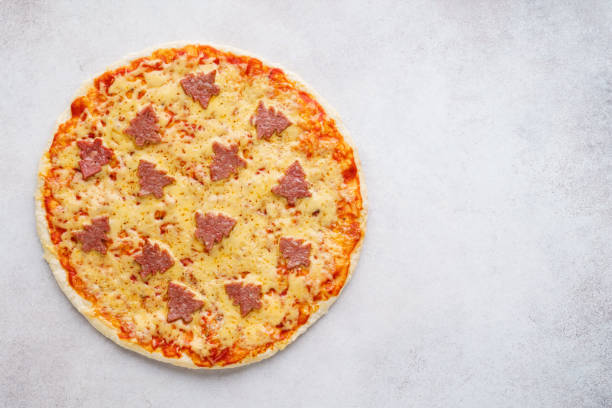 istock Pizza decorated with pepperoni shaped as Christmas trees. 1183295503