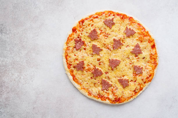 istock Pizza decorated with pepperoni shaped as Christmas trees. 1183295729