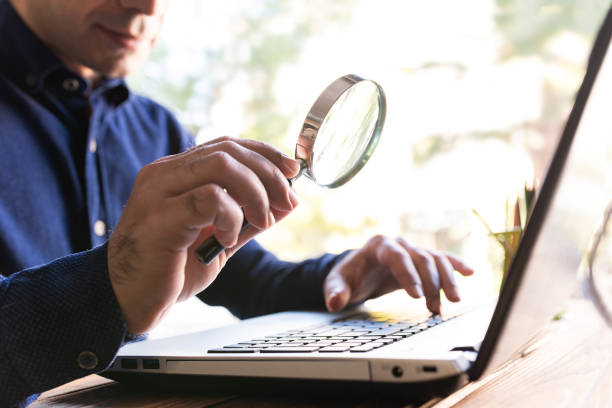 Man Holding a Magnifying Glass Searching On Internet