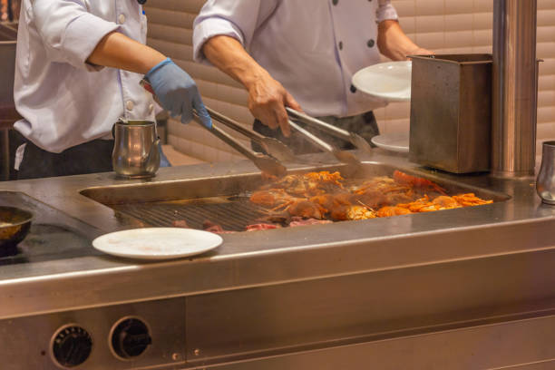 istock Two chef preparing grilled lobsters on electric stove in kitchen 1183298481