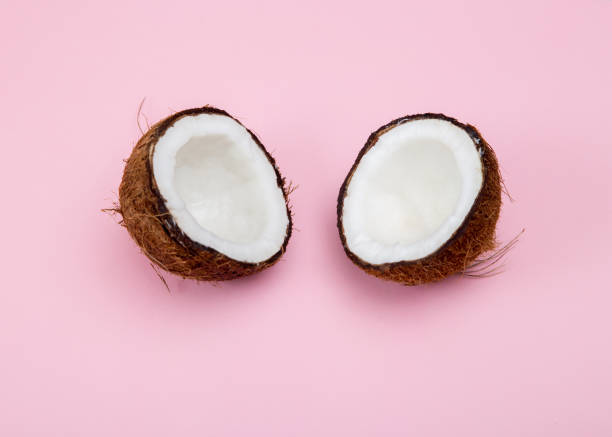 istock Fresh raw coconut cut into 2 parts on a pink background. 1183299723