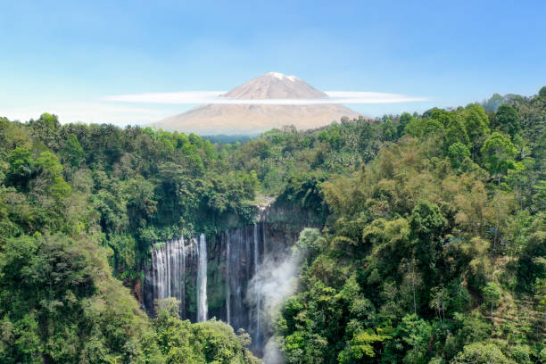 Waterfall, volcano and tropical rainforest in Indonesia Aerial view of Tumpak Sewu waterfall and Semeru Volcano at sunrise located in east java, Lumajang, Indonesia. Natural landscape background. bromo tengger semeru national park stock pictures, royalty-free photos & images