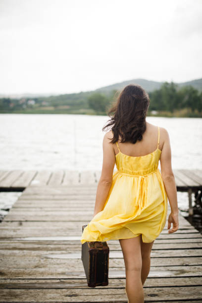 istock Young woman with suitcase on the pier. 1183301704