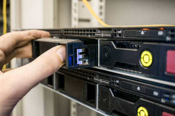 remplacement d'un disque dur dans le matériel informatique. réparation modulaire du matériel serveur de base de données. le travail technique dans la salle des serveurs du centre de données est un gros plan. - network server data center installing photos et images de collection