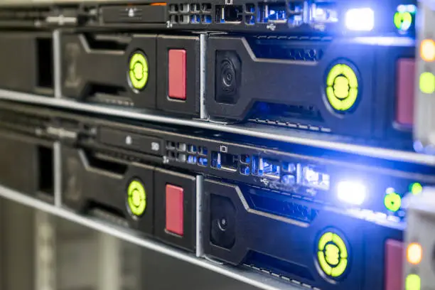 Photo of Modern computer equipment is installed in the server room. Many hard drives are in a powerful router on the hosting site. The database server is in the rack of the data center.