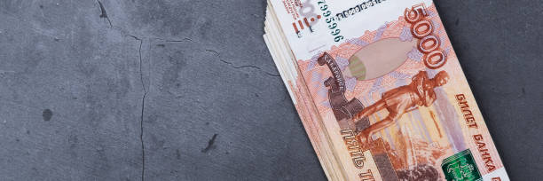 istock Big stack of Russian money banknotes of five thousand rubles lying on a grey cement background. 1183302780