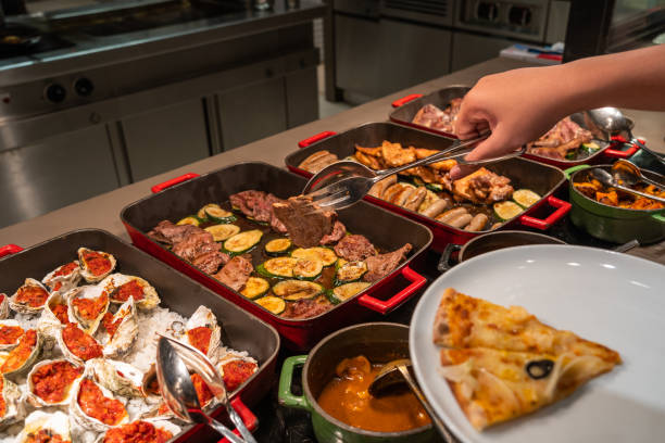 istock Human hand picking assorted food in luxury buffet meal 1183302789