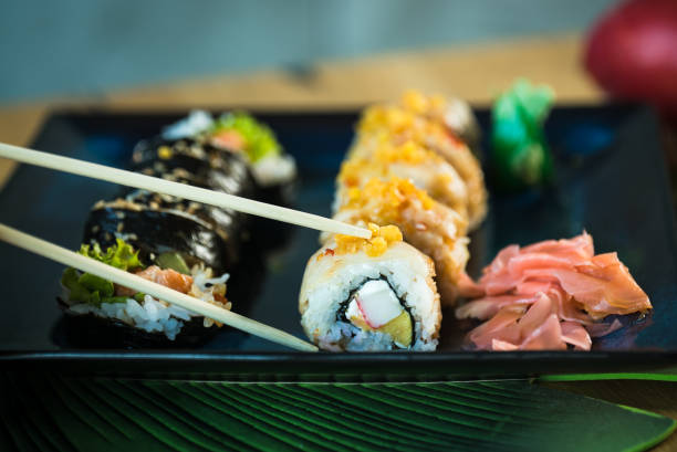 istock Sushi Set. Various rolls on a wooden plate. On dark rustic background 1183303139