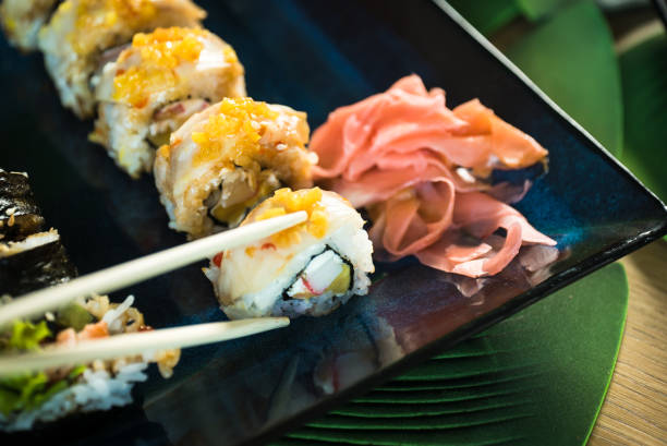istock Sushi Set. Various rolls on a wooden plate. On dark rustic background 1183303180