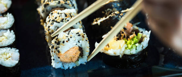 istock Sushi Set. Various rolls on a wooden plate. On dark rustic background 1183303211