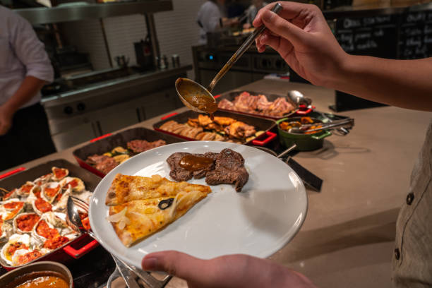 istock Human hand picking food into his plate in buffet restaurant 1183303825
