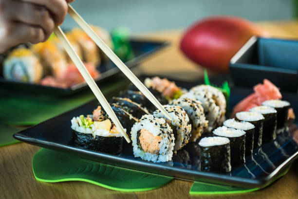 istock Sushi Set. Various rolls on a wooden plate. On dark rustic background 1183304136